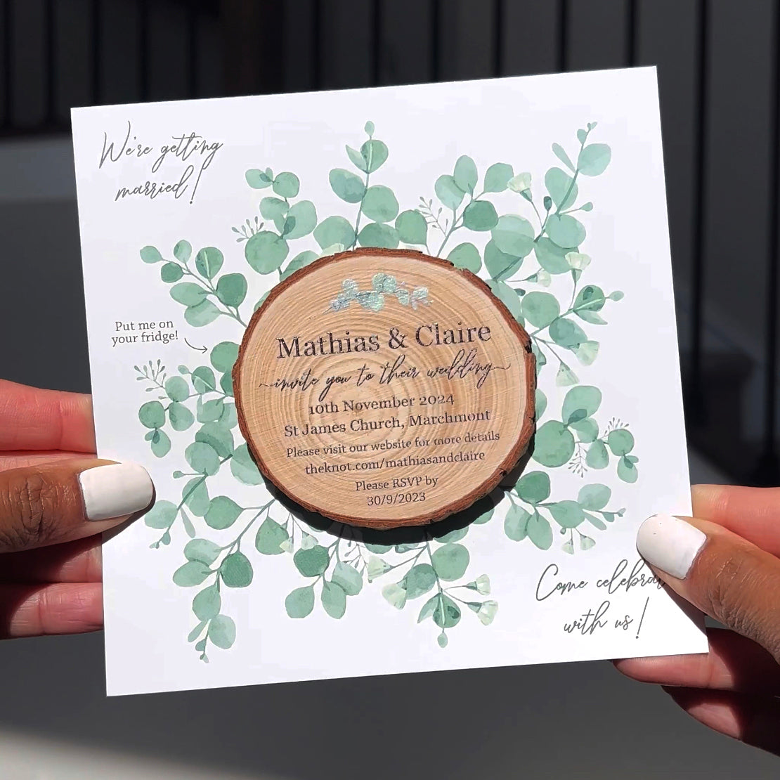 person holding wood slice invite with eucalyptus card