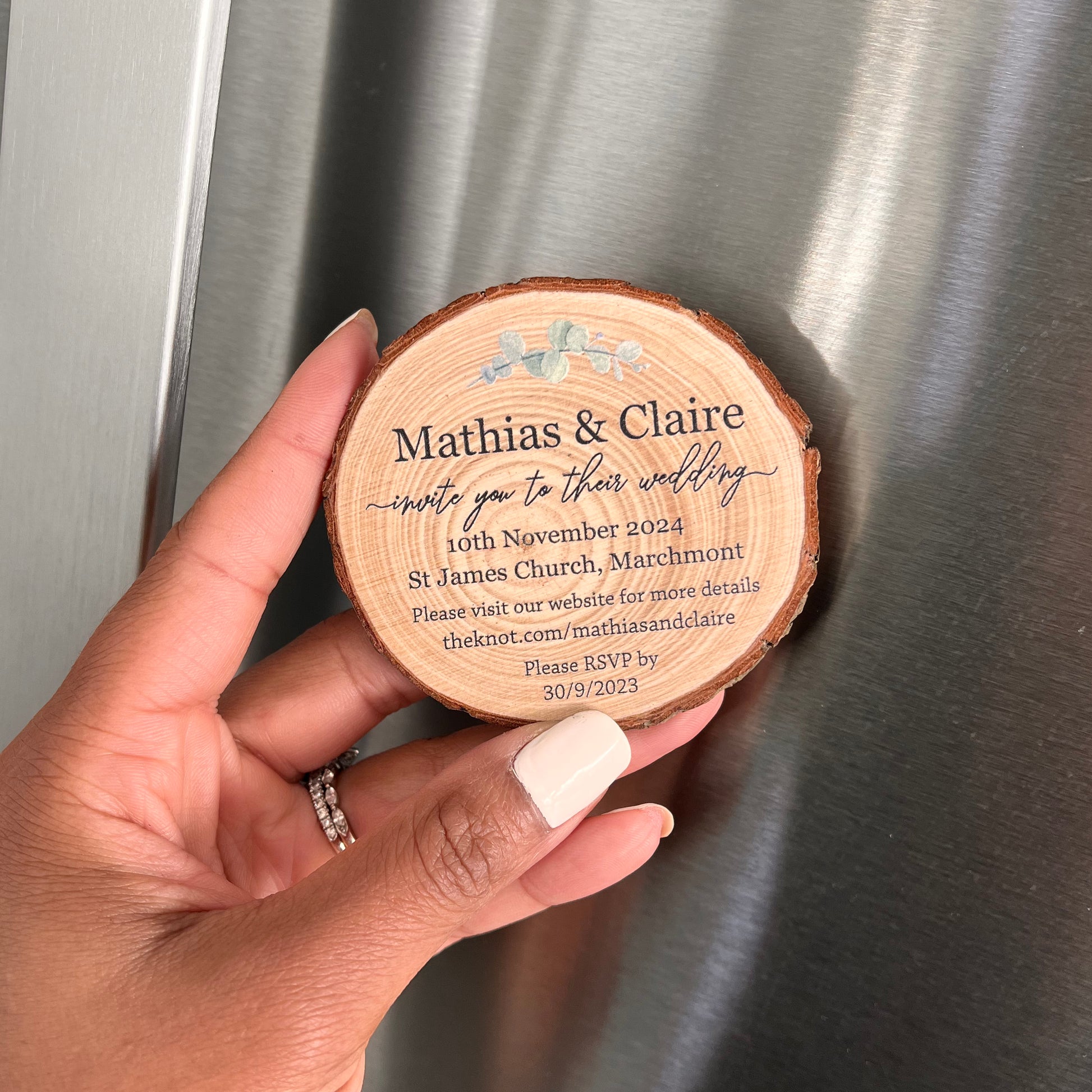 wood slice magnet about to be placed on fridge