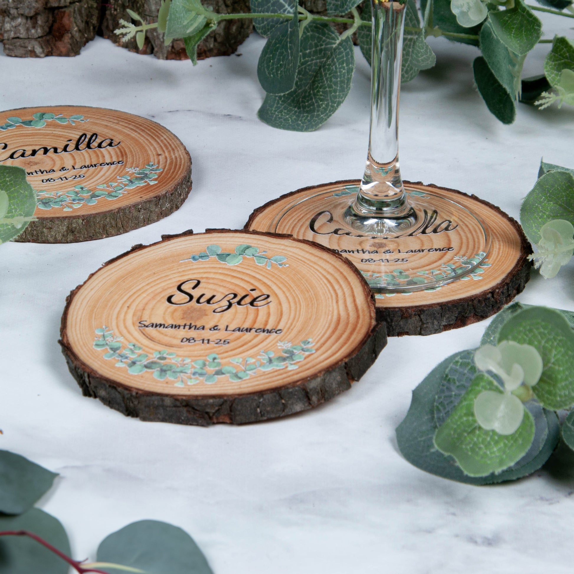 Side view of wood slice wedding favour coaster with eucalyptus design