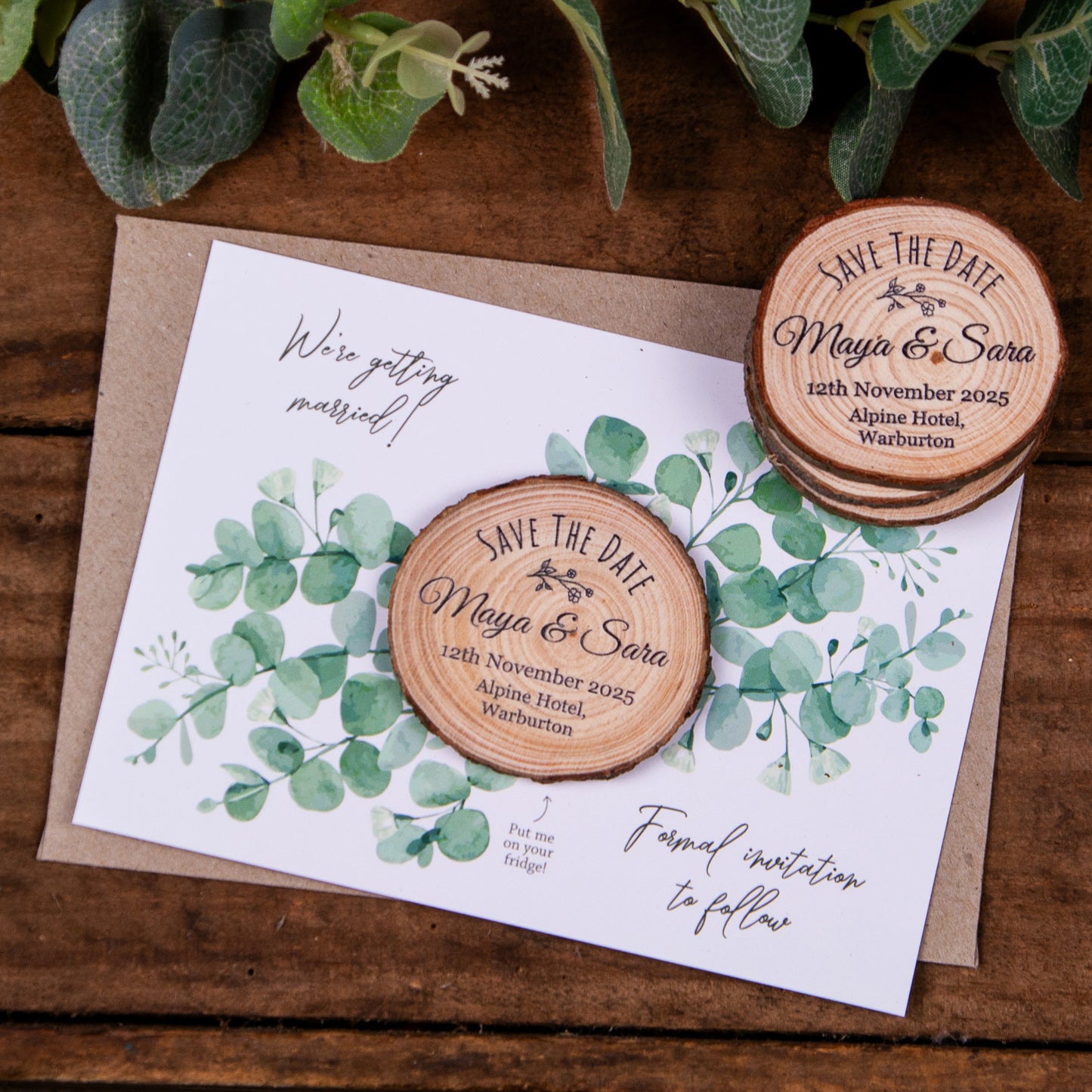 wedding save the date magnet with eucalyptus design card and personalised wood slice