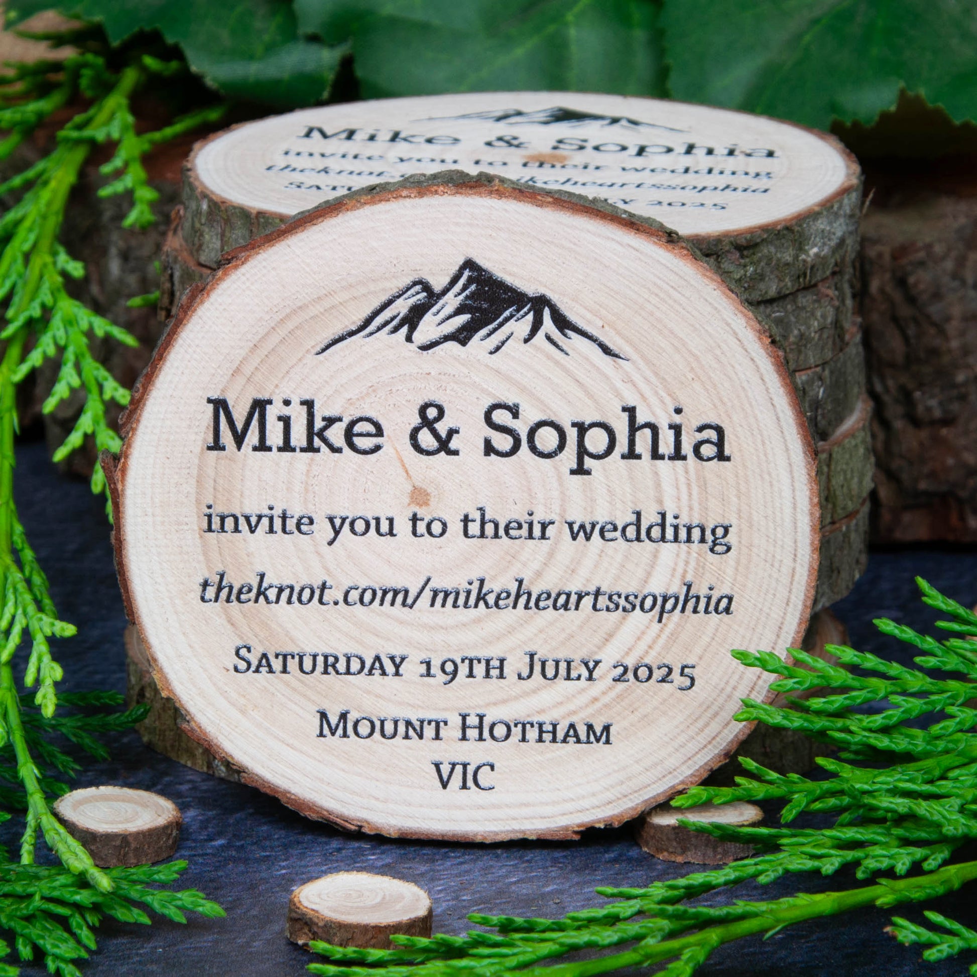 Mountain style wedding invite on a rustic wood slice